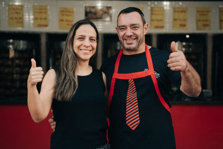 João Marcelo e sua sócia fazendo sinal de positivo na loja